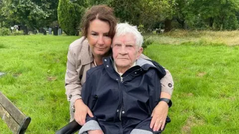 BBC Jo Norton with her arms around her mother Betty Rawsthorne in a cemetery