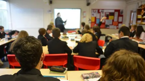 Teacher using white board during lesson