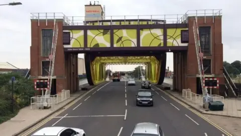 Hull's Drypool Bridge a brick and steel construction decorated with green and brown panels commemorating John Venn with cars driving over it