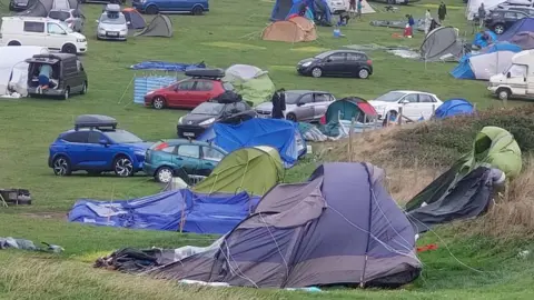 Mike Harris Damaged tents as campers survey the scene on Saturday morning