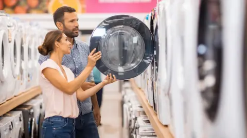 Getty Images Couple looking at a washing machine in a shop