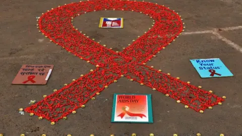 Getty Images A red ribbon mural during an awareness campaign on AIDS, at Baje Kadamtala Ghat, on December 1, 2019 in Kolkata, India.