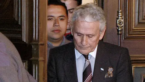 AFP The former director of investigations of the Buenos Aires police, Miguel Etchecolatz (c), arrives for the opening hearings of his trial on abduction, torture and murder charges for his role during the 1976-1983 military dictatorship, the first such trial ever in Argentina, 20 June 2006 in La Plata