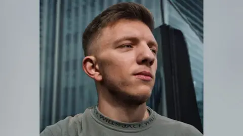 SUPPLIED A man looking off to the right, wearing a grey jumper