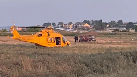 Letitia Etherington A yellow air ambulance which has landed in a field