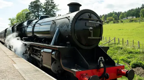 Studio Lambert A black steam locomotive.