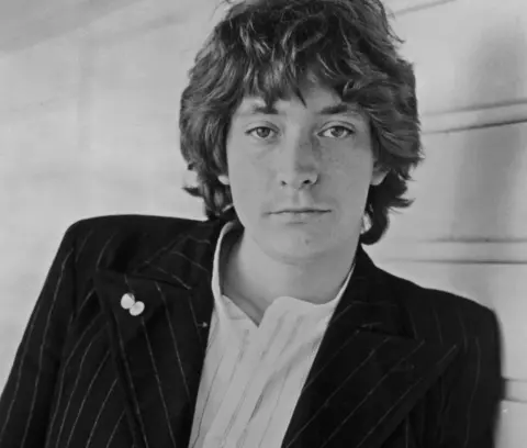 Getty Images Chris Rea in a black and white phote in a white shirt and black jacket