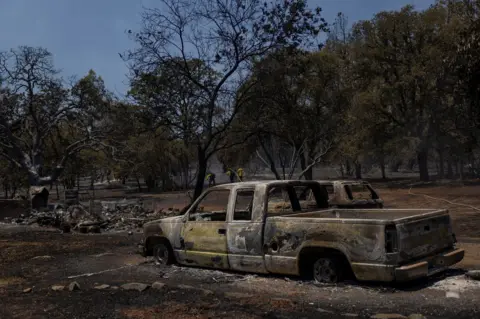 Reuters Firefighters work near burned vehicles in Oroville, California 