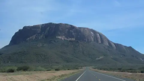 Mount Ololokwe is seen in the background of a highway 