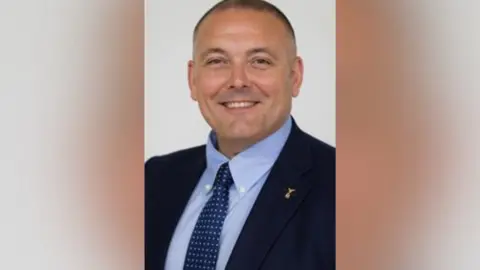 Leicestershire County Council A man in a suit and jacket.