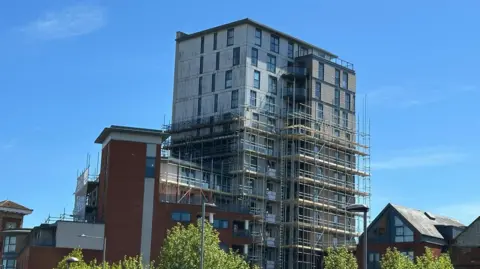 The tower of Regatta quay with scaffolding along part of it.  