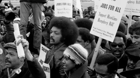 Getty Images A black and white photo of a young Jesse Jackson taking part in a march for jobs