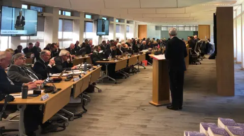 Tim Oliver makes a speech at a meeting of Surrey County Council in the offices at Woodhatch Place in Reigate.