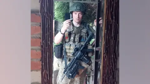 Sergiy Sylantyev Sergiy Sylantyev, a man in Ukraine's military uniform, with a machine gun, taking a selfie.