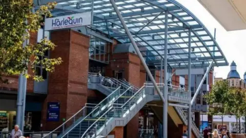 Harlequin Theatre and Cinema The facade of a building is shown with red bricks and grey metal.