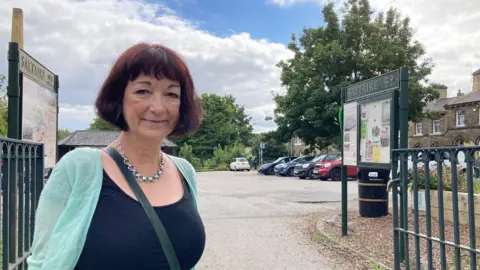 SOS campaigner Kate Rawnsley standing in between the Caroline Street car park gates