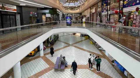 An almost empty Ridings shopping centre with just a few visitors and several closed shops.