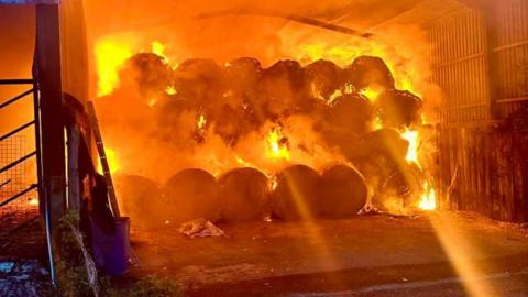 Orange flow as barn full of bales erupts into flames