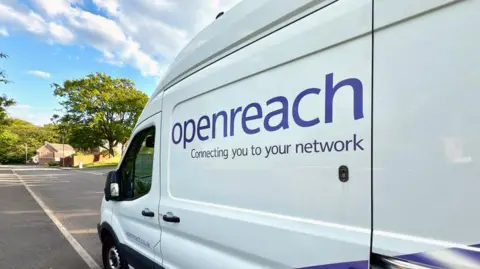 A white van driving on a road, with open reach sign on the van 