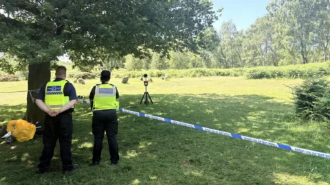 Derbyshire Police Police cordon with officers facing away from the camera