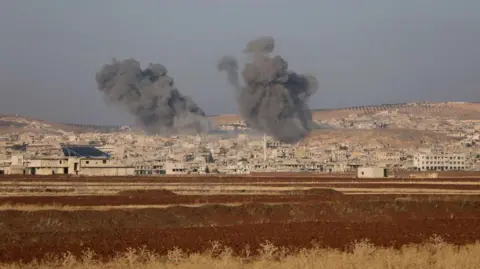 AFP Smoke billows the the Syrian town of Suran, between Aleppo and Hama (3 December 2024)