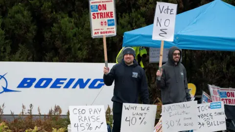 Reuters Striking Boeing workers hold signs on a picket line near the entrance to a Boeing production facility in Renton, Washington.