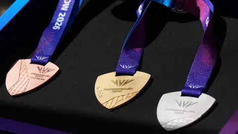 Getty Images Bronze, gold and silver Commonwealth Games medals - with a purple ribbon -against a black backdrop.