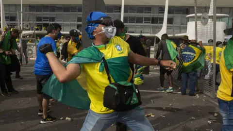 Getty Images Supporters of former President Jair Bolsonaro clash with security forces as they raid the National Congress in Brasilia