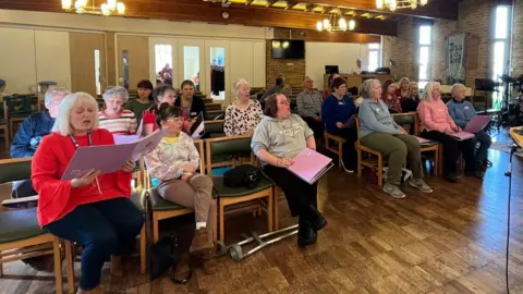 Holly Nichols/BBC A choir performing at the chirch of the holy spirit