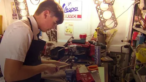 Boy making flowers out of scrap metal