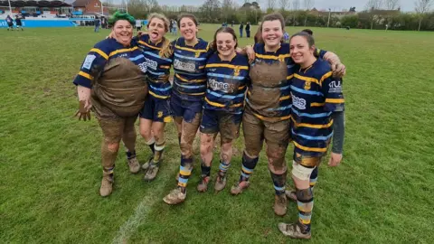 Trowbridge RFC A women's rugby team covered in mud