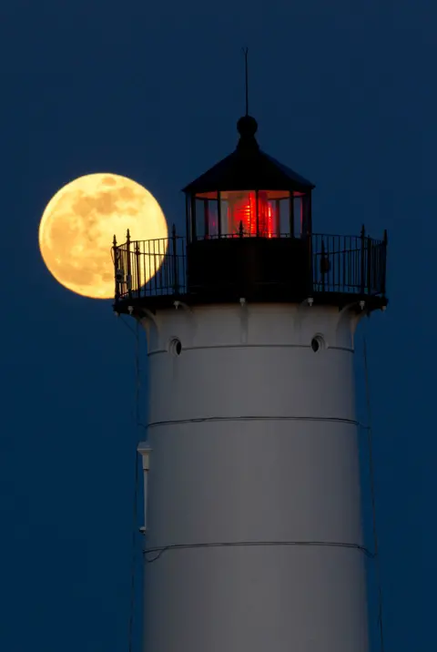 EPA The supermoon rising behind the Nubble Lighthouse on Cape Neddick, in York, Maine, US