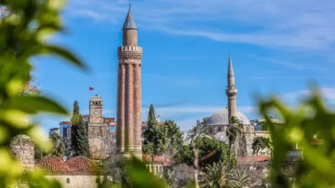 Getty Images : A view of the Yivli Minaret Mosque and Kaleici clock tower located in the old town of Kaleici, one of the tourist attractions in Antalya, Turkey on March 2, 2018.