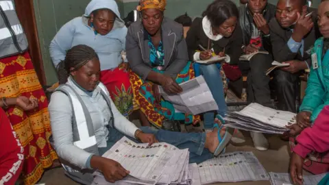 Getty Images People looking at the votes being counted