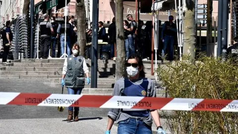 Getty Images French Police officers wearing protective masks and gloves walk in a street in the centre of Romans-sur-Isere