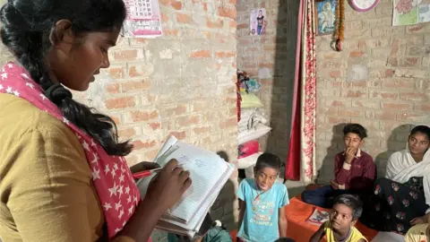 Divya Arya/BBC Rashmi seen taking a class at their home