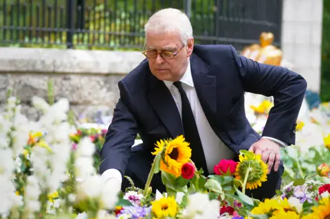 Getty Images Prince Andrew looks at messages and floral tributes for his mother, Queen Elizabeth II, September 2022