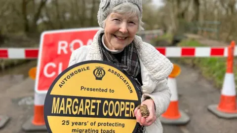 Woman with disc and toad in hand