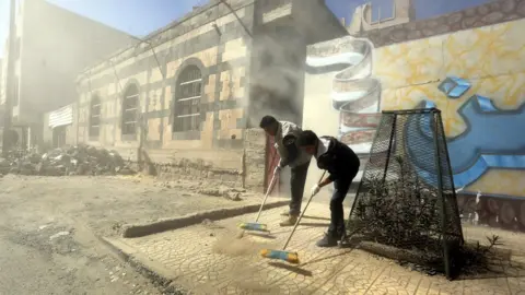 EPA Yemenis clean up a street in Sanaa during a clean-up campaign (12 December 2017)