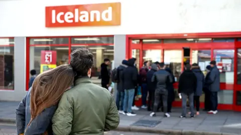 Getty Images People stand outside Iceland store