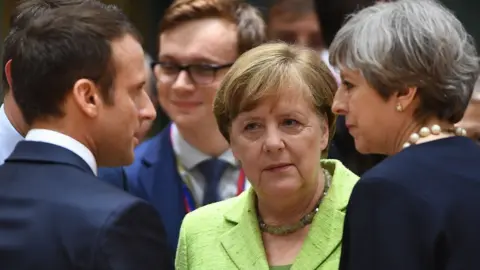 AFP French President Emmanuel Macron (L), German Chancellor Angela Merkel and British Prime Minister Theresa May in Brussels, 22 Jun 17