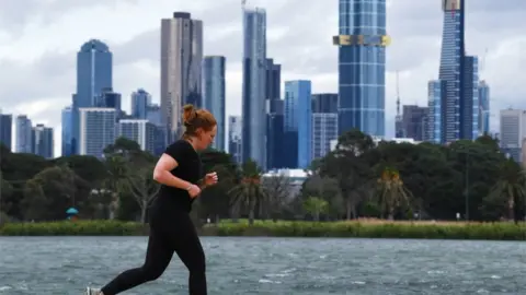 EPA A woman jogs in Melbourne