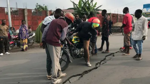 Reuters Goma residents inspect a large crack in the ground caused by aftershocks of last weekend's eruption