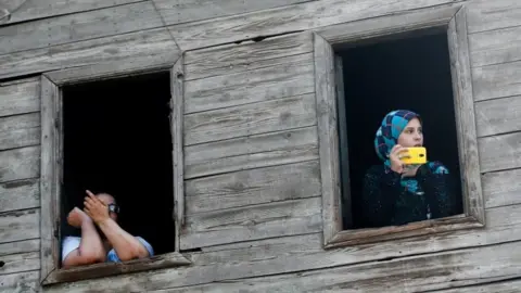 Reuters An Egyptian woman looks from the window as her daughter takes pictures during the funeral of Syed Tafshan, who died in clashes with residents of the Nile island of al-Warraq island, when security forces attempted to demolish illegal buildings, in the south of Cairo, Egypt July 16, 2017.