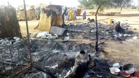 Getty Images Smouldering ashes are seen on the ground in Badu near Maiduguri on July 28, 2019, after the latest attack this weekend by Boko Haram fighters on a funeral in northeast Nigeria has left 65 people dead