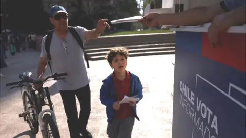 Reuters Un ciudadano recibe una copia del borrador de la nueva constitución de Chile antes del referéndum constitucional del 17 de diciembre, frente al palacio de gobierno.