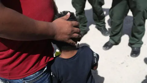 Getty Images A small boy from Honduras and his father are taken into custody by US Border Patrol agents near the US-Mexico Border on June 12, 2018 near Mission, Texas.