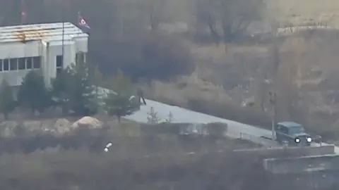 UN Command Screengrab of video clips showing North Korean soldier defecting to the South at the JSA