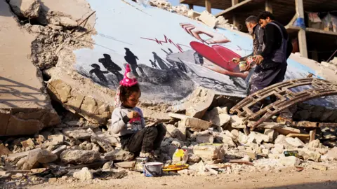 Getty Images Syrian graffiti artists paint the struggle of the earthquakes on the rubble of a collapsed building at Jindires, a district of Afrin, Syria - 22 February