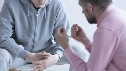 Getty Images Psychologist interviewing his patient during a therapy counselling session